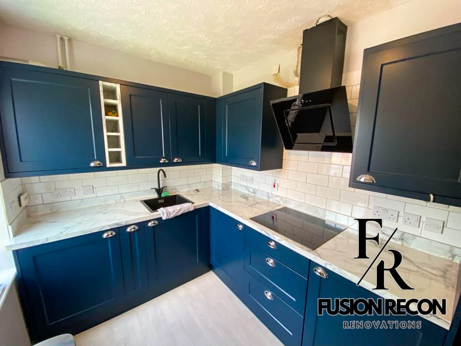 Navy blue shaker-style kitchen with quartz countertop and brass handles – Putney SW15